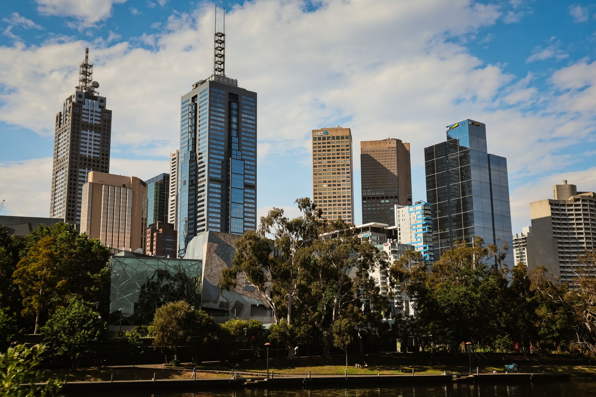 City park with lake and the buildings beyond.